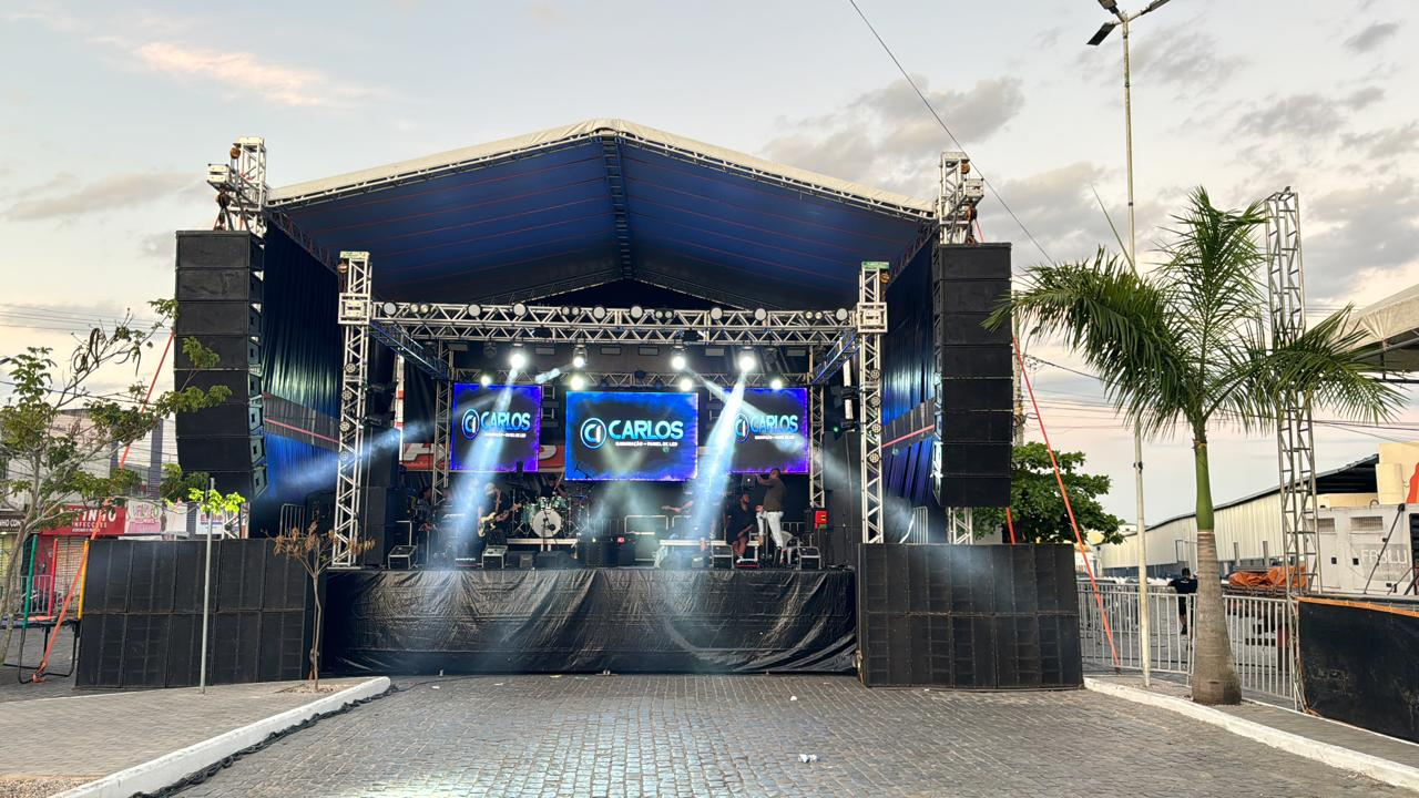 Vista frontal de palco coberto com sonorização e iluminação